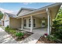 Charming home with a covered front porch, neutral siding and well-maintained landscaping at 1730 Dorset Dr, Mount Dora, FL 32757