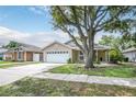 Charming single-story home with attached garage and mature tree in front yard at 1730 Dorset Dr, Mount Dora, FL 32757