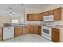 Functional kitchen features updated countertops, white appliances, and oak wood cabinets at 1730 Dorset Dr, Mount Dora, FL 32757