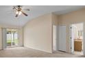 Comfortable main bedroom featuring carpet, a ceiling fan, patio access, and an en-suite bathroom at 1730 Dorset Dr, Mount Dora, FL 32757