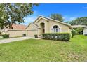 Well-kept single-story home featuring lush green lawn and established landscaping around the perimeter at 17428 Woodfair Dr, Clermont, FL 34711