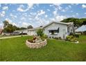 Landscaped front yard with vibrant flowerbeds, healthy green lawn, and a charming flower planter at 17533 Se 96Th Ct, Summerfield, FL 34491