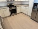 Well-lit kitchen featuring stainless steel appliances, light countertops, and white cabinets at 1964 Rhett Rd, The Villages, FL 32163