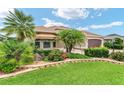 Beautiful single-story home featuring well-manicured landscaping and a two-car garage at 219 Carrera Dr, The Villages, FL 32159