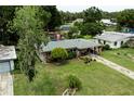 A well-maintained single-story house with a neatly landscaped front yard, carport, and a cozy front porch at 2202 Butler St, Leesburg, FL 34748