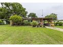 Charming single-story home with a covered carport, well-kept lawn and mature landscaping at 2202 Butler St, Leesburg, FL 34748