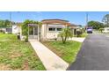 Inviting single-story home featuring a cozy entrance with a small tree and well-maintained front yard at 239 Rue De Fontaine, Tavares, FL 32778