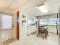 A quaint kitchen features white cabinets, pink countertops, and a dining area perfect for casual meals at 239 Rue De Fontaine, Tavares, FL 32778