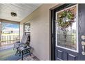 Cozy front porch featuring a chair, side table, and a decorative wreath on the front door at 26601 Otter Creek Ln, Leesburg, FL 34748