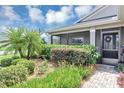 Inviting front porch with a seating area, complemented by lush landscaping and a decorative wreath at 26601 Otter Creek Ln, Leesburg, FL 34748