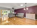 Bright living room with beautiful hardwood floors, skylight, and comfortable seating at 26917 White Plains Way, Leesburg, FL 34748