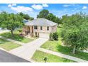 Beautiful two-story home with a well-maintained lawn, mature trees, and a spacious driveway at 2745 Shearwater St, Clermont, FL 34711