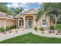 Welcoming front entrance with arched doorway, manicured landscaping, and well-kept lawn offering a pleasant curb appeal at 33943 E Lake Joanna Dr, Eustis, FL 32736