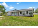 A quaint single-story house featuring a well-kept lawn, light gray facade and bright white trim at 4 Kristin Ln, Eustis, FL 32726