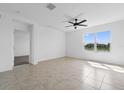 A spacious bedroom with a ceiling fan, carpet flooring, and lake views at 424 Noble Ave, Davenport, FL 33837