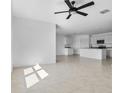 Open-concept living space with tile flooring and an adjacent kitchen area at 424 Noble Ave, Davenport, FL 33837