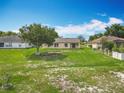Expansive backyard featuring a large tree and lush lawn, offering ample space for outdoor activities at 439 Gentle Breeze Dr, Minneola, FL 34715