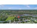 Scenic aerial view of home nestled in a lush, green neighborhood with a tranquil lake at 5144 Rishley Run Way, Mount Dora, FL 32757