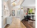 Inviting foyer with tile floors, grand staircase, chandelier and stylish decor at 5144 Rishley Run Way, Mount Dora, FL 32757