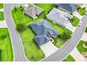Overhead view of beautiful gray home with well-kept lawn and street, surrounded by other similar homes in the neighborhood at 5868 Wood Stork Way, The Villages, FL 32163