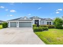 Charming single-story home with a well-manicured lawn, a three-car garage, and a welcoming front entrance at 5868 Wood Stork Way, The Villages, FL 32163
