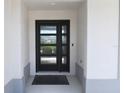 Stylish front door with glass panels and a welcoming entryway with black doormat at 6301 Danielson Loop, The Villages, FL 32163