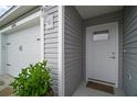 Close-up featuring a well-lit front door with stylish grey siding and white trim at 6342 Whittle Ct, The Villages, FL 32163