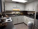 Well-lit kitchen features white cabinets, a double basin sink, and stainless steel appliances at 679 Avenue Q Se, Winter Haven, FL 33880