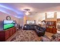 Spacious living room featuring plush seating, a modern entertainment center, and an open floor plan at 8489 Se 158Th Pl, Summerfield, FL 34491