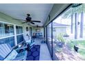 Cozy screened porch with comfortable seating, ceiling fans, and a view of the outdoors at 8489 Se 158Th Pl, Summerfield, FL 34491