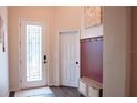 Welcoming foyer featuring wood-look tile flooring, a decorative bench and a paneled accent wall at 9219 Chandler Dr, Groveland, FL 34736