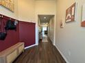 Inviting foyer with wood-look tile, paneled accent wall, bench and decor at 9219 Chandler Dr, Groveland, FL 34736