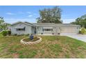 Inviting single-story home with a well-kept lawn, landscaped flower beds, and a two-car garage at 9499 Se 174Th Loop, Summerfield, FL 34491