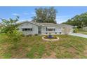 Welcoming single-story home with a lush lawn, vibrant flower beds, and a well-manicured garden at 9499 Se 174Th Loop, Summerfield, FL 34491