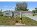 Beautiful single-story home with a manicured lawn, flower beds, and a charming white picket fence at 9499 Se 174Th Loop, Summerfield, FL 34491