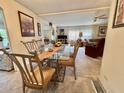 Open-concept dining area with glass table and seating that flows into the living room at 105 Avocado Cv, Leesburg, FL 34748