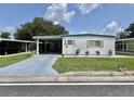 Charming single-story home with carport, well-maintained lawn, and beautiful landscaping at 105 Avocado Cv, Leesburg, FL 34748