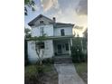 Image of a two-story home with a covered front porch and traditional design awaiting restoration at 110 S Trowell Ave, Umatilla, FL 32784