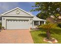 Charming single-story home with well-maintained landscaping, a brick driveway, and a cozy front porch at 1180 Mesa Verde Ct, Clermont, FL 34711