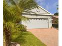 Spacious two-car garage with decorative windows and a brick-paved driveway, enhancing the home's curb appeal at 1180 Mesa Verde Ct, Clermont, FL 34711
