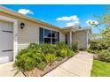 Landscaped front yard with lush bushes and colorful plants leading to a welcoming home entrance at 1224 Ballesteros Dr, The Villages, FL 32162
