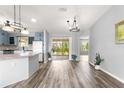 Spacious living area featuring vinyl floors, neutral paint, a large glass slider and kitchen view at 1224 Ballesteros Dr, The Villages, FL 32162