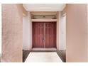 View of the mahogany double front doors, complemented by a transom window at 12947 Se 97Th Terrace Rd, Summerfield, FL 34491