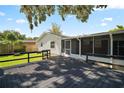 Backyard with a wooden deck, screened patio, and grassy area with mature trees at 1301 Cambridge Dr, Leesburg, FL 34748