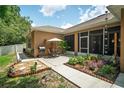 Back patio area with an outdoor grill, table, chairs, and lush landscaping at 1556 Blue Grass Blvd, Deland, FL 32724