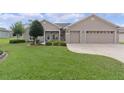 Attractive exterior featuring a manicured lawn and a convenient two-car garage at 17355 Se 110Th Ter, Summerfield, FL 34491