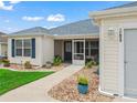 Inviting front entrance with a screened-in porch and neatly landscaped surroundings at 17824 Se 87Th Bourne Ave, The Villages, FL 32162