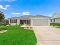 Lovely single-story home with a well-kept lawn, mature landscaping, and inviting curb appeal at 17824 Se 87Th Bourne Ave, The Villages, FL 32162