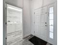 Bright entryway with a laundry room view, featuring tile floors and a clean, welcoming aesthetic at 2019 Newtown Rd, Groveland, FL 34736