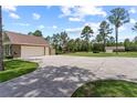 Spacious drive featuring a detached garage, additional building, and expansive lawn at 23247 Lake Seneca Rd, Eustis, FL 32736